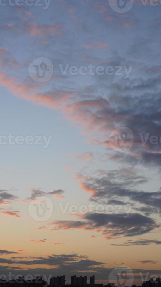 a bela vista do pôr do sol com as nuvens coloridas e o céu da cidade foto