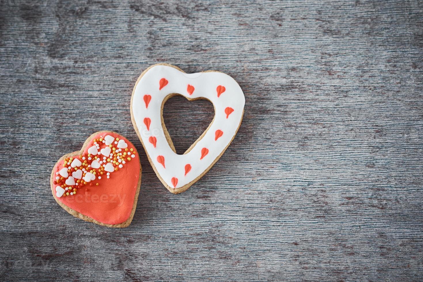 dois biscoitos decorados em forma de coração no fundo cinza com espaço de cópia. conceito de comida de dia dos namorados foto