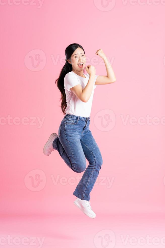 imagem de corpo inteiro de menina asiática posando em fundo rosa foto