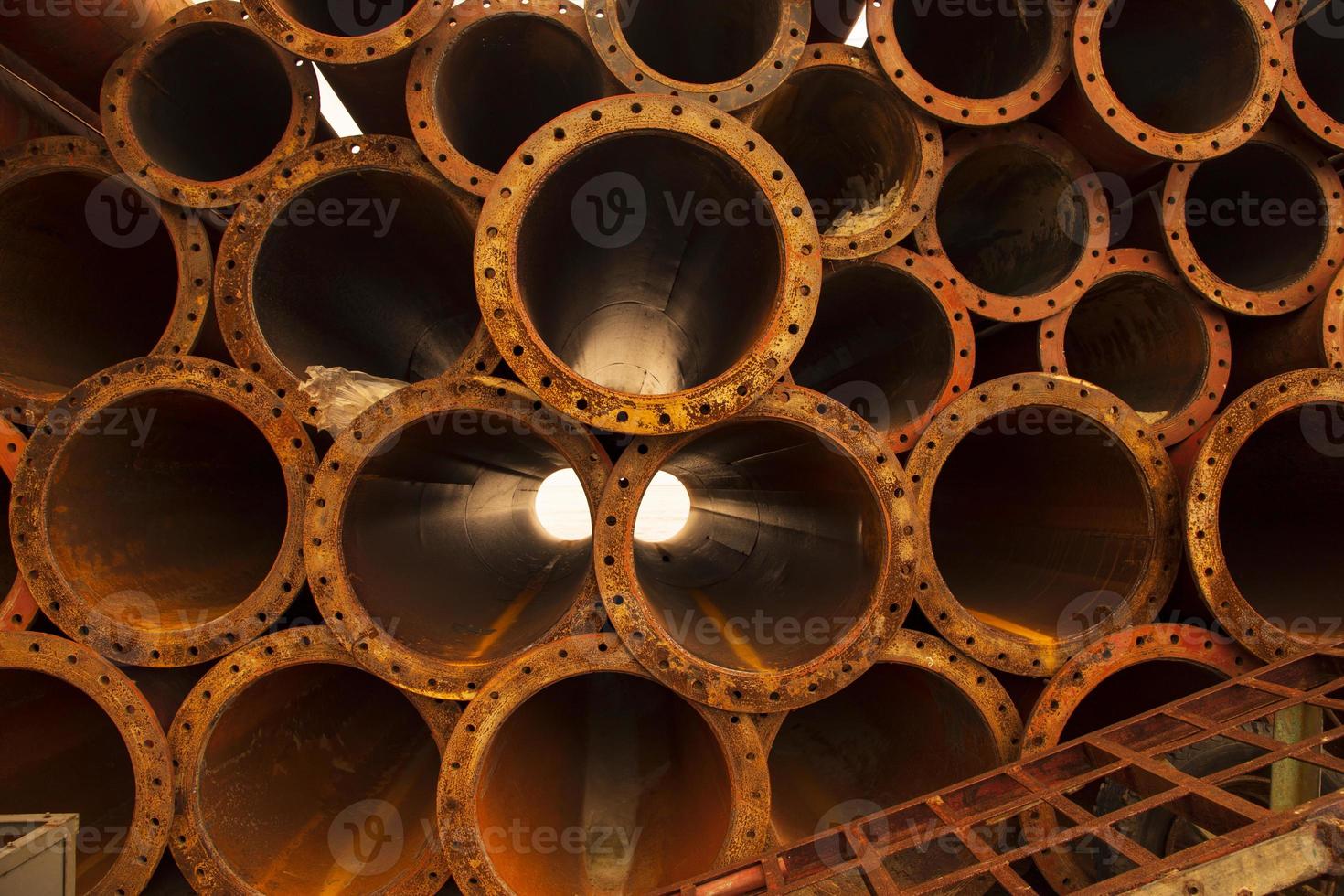 um fundo industrial de textura de pilha de tubos de ferro enferrujado foto