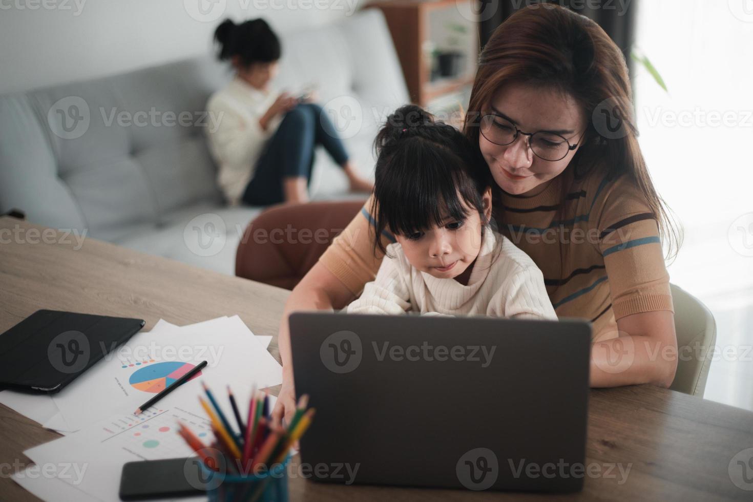 mãe trabalhando em home-office com filha no colo foto