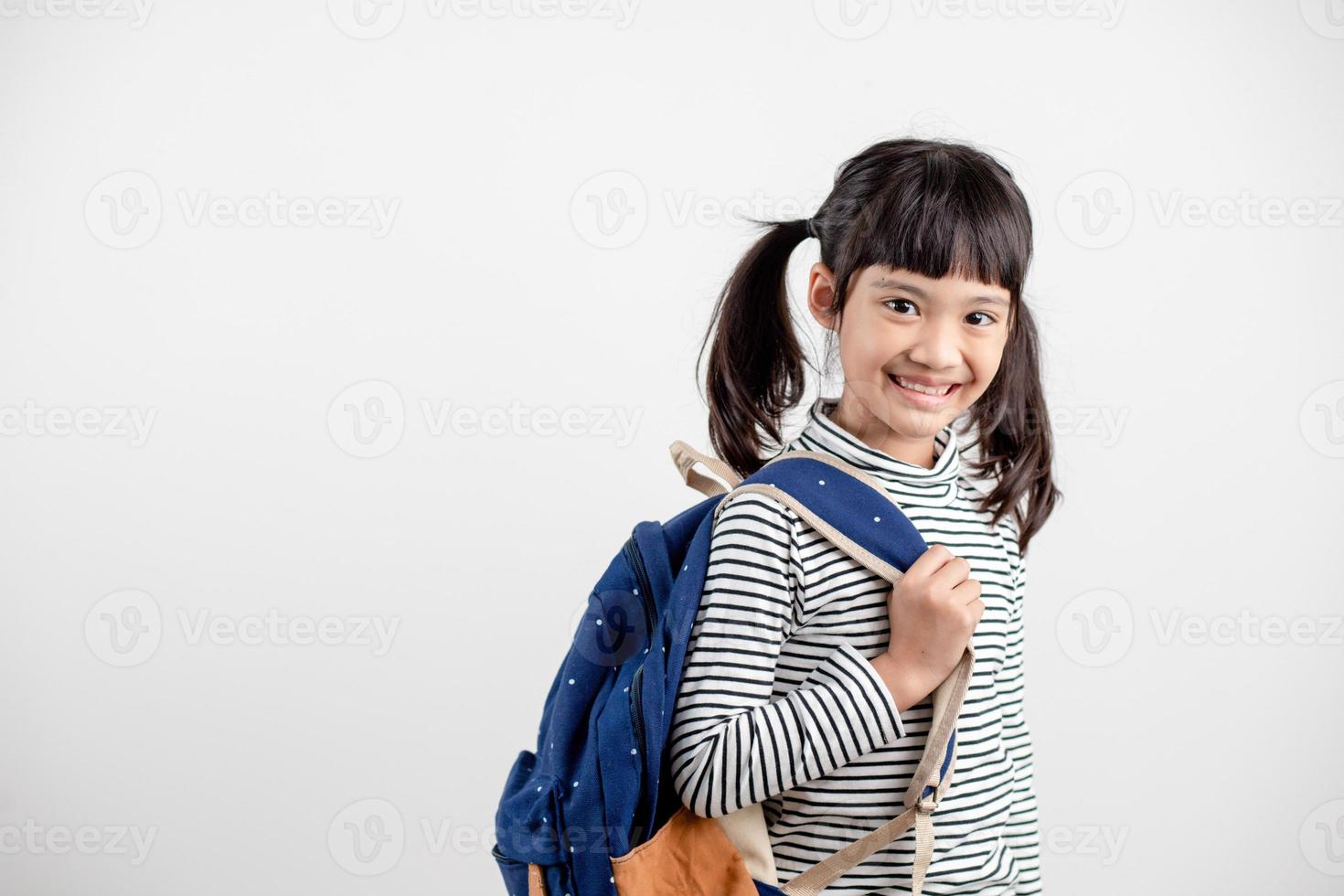 retrato de criança asiática em uniforme escolar com mochila em fundo branco foto