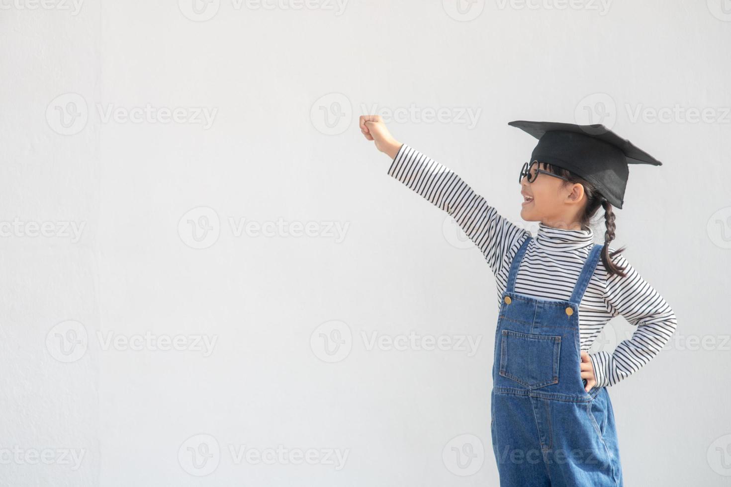 menina de crianças vestindo um boné de pós-graduação sobre fundo branco muito feliz e animado fazendo gesto de vencedor com os braços levantados, sorrindo e gritando para o sucesso. conceito de celebração. foto