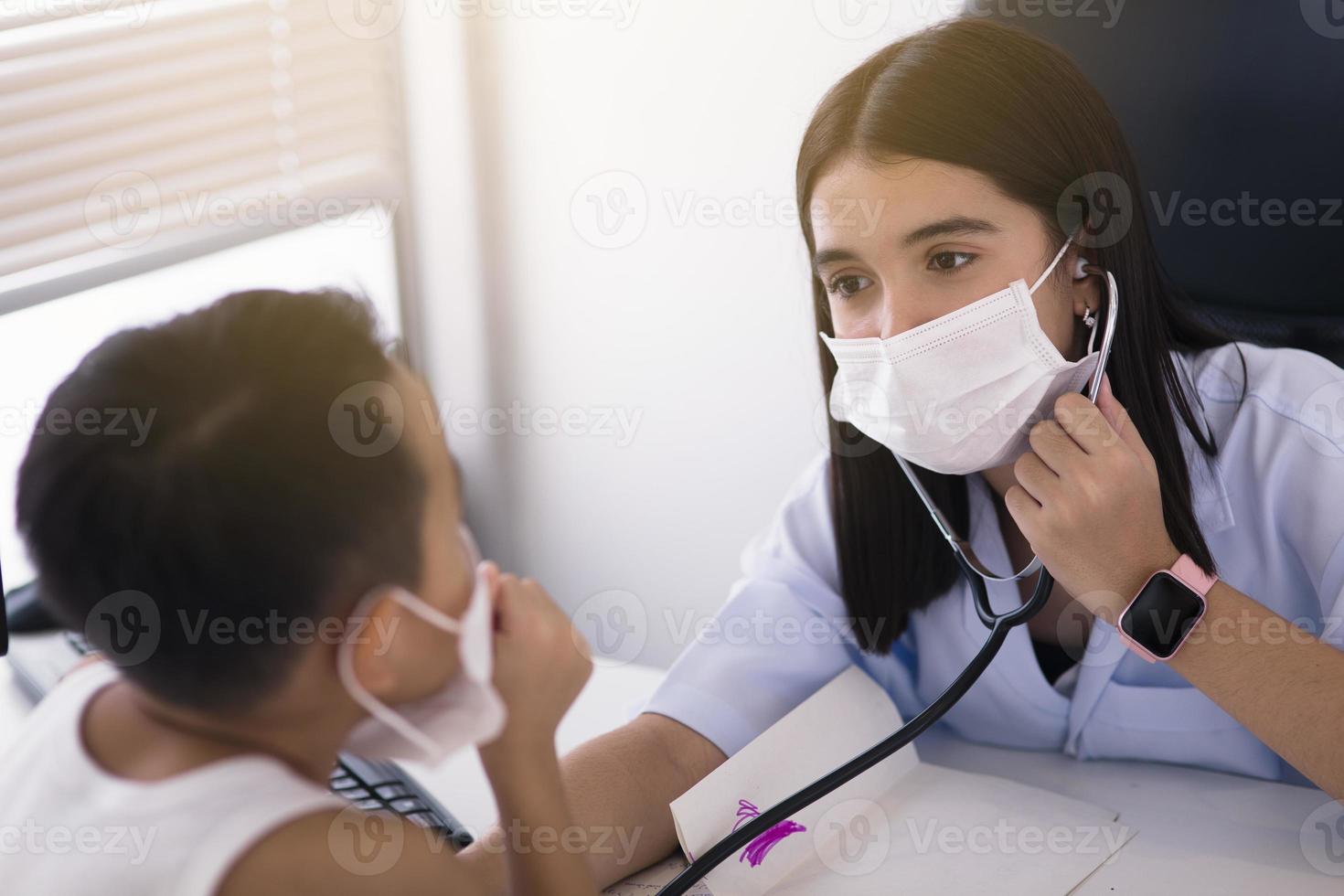 uma médica asiática usando uma máscara cirúrgica está derramando álcool gel na mão do paciente. foto