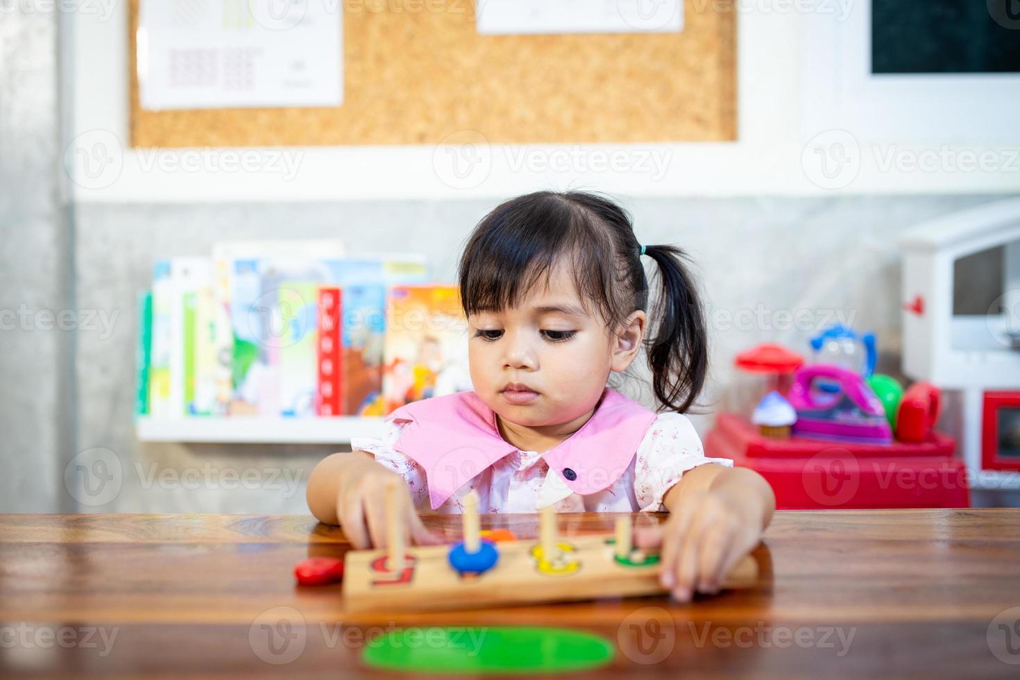 criança menina jogando brinquedos de madeira foto