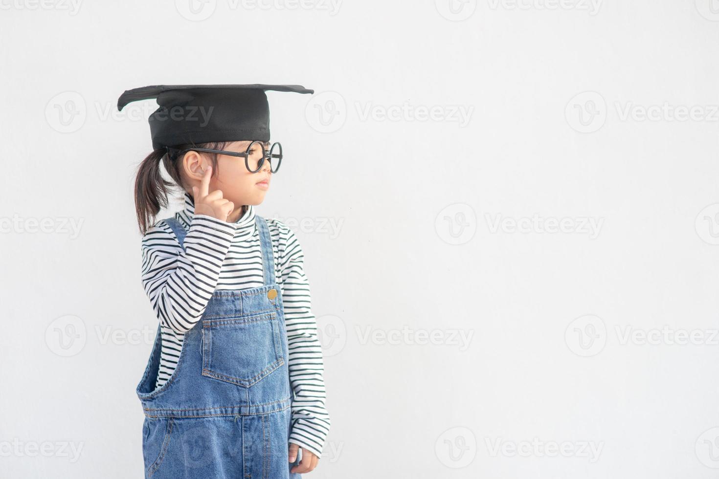 feliz estudante de escola asiática graduado pensando com boné de formatura foto