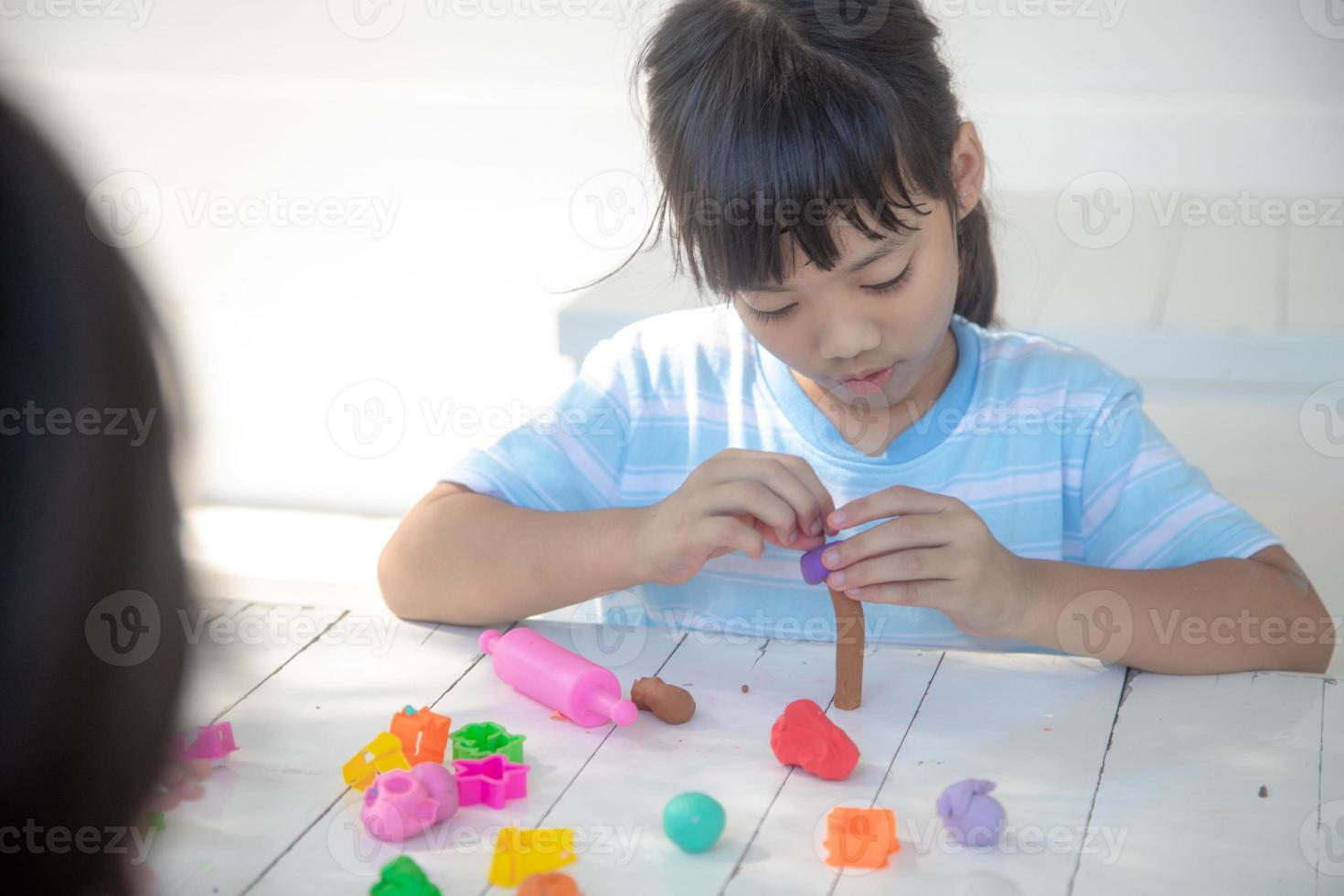 crianças asiáticas brincam com formas de moldagem de argila, aprendendo brincando foto