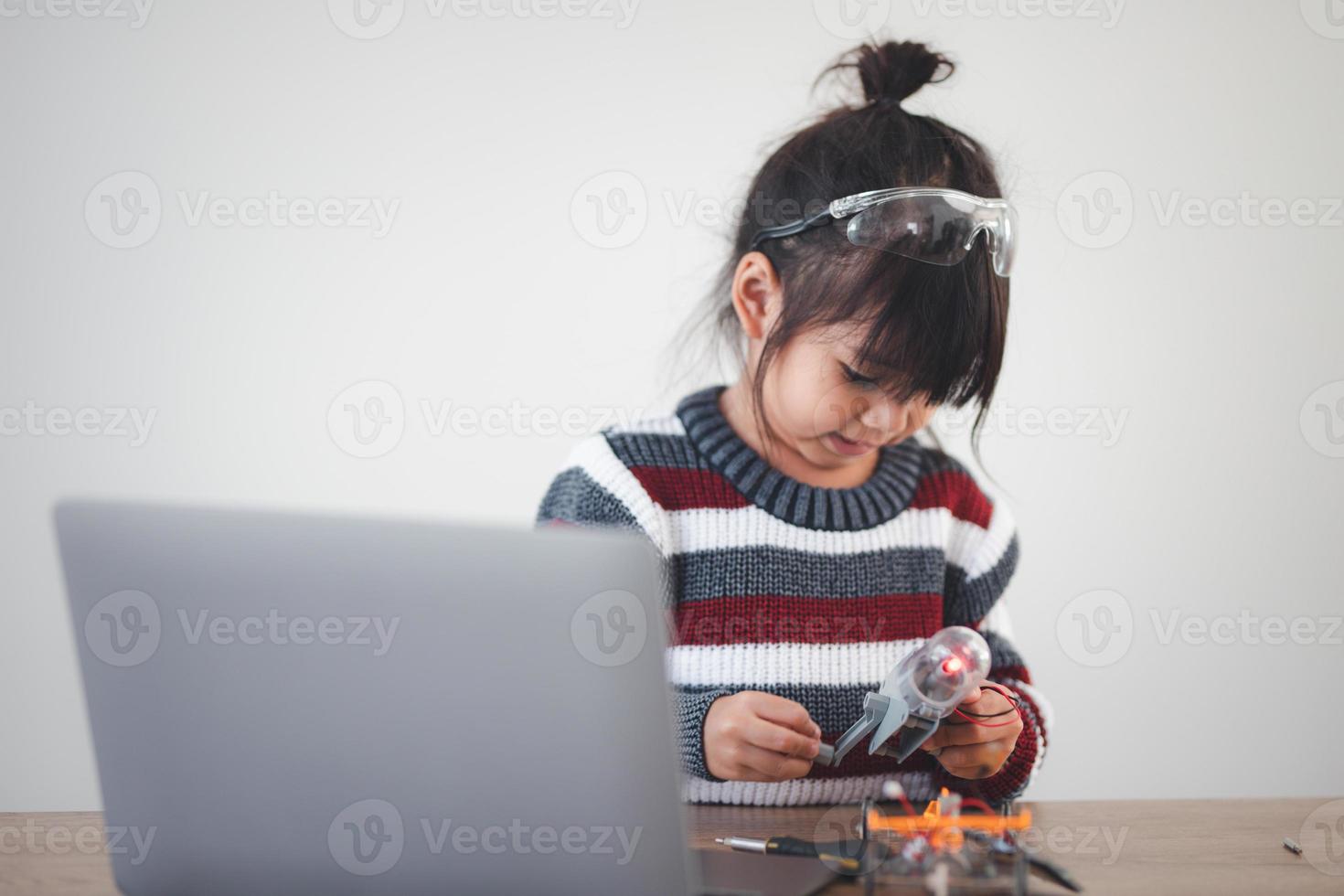 criança inventiva construindo carros-robô em casa foto