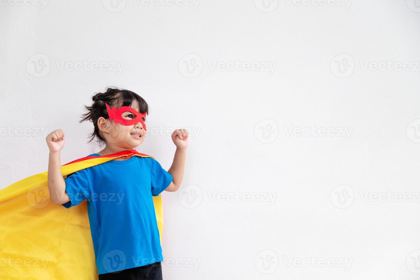 menina criança joga super-herói. criança em fundo branco. conceito de poder feminino foto