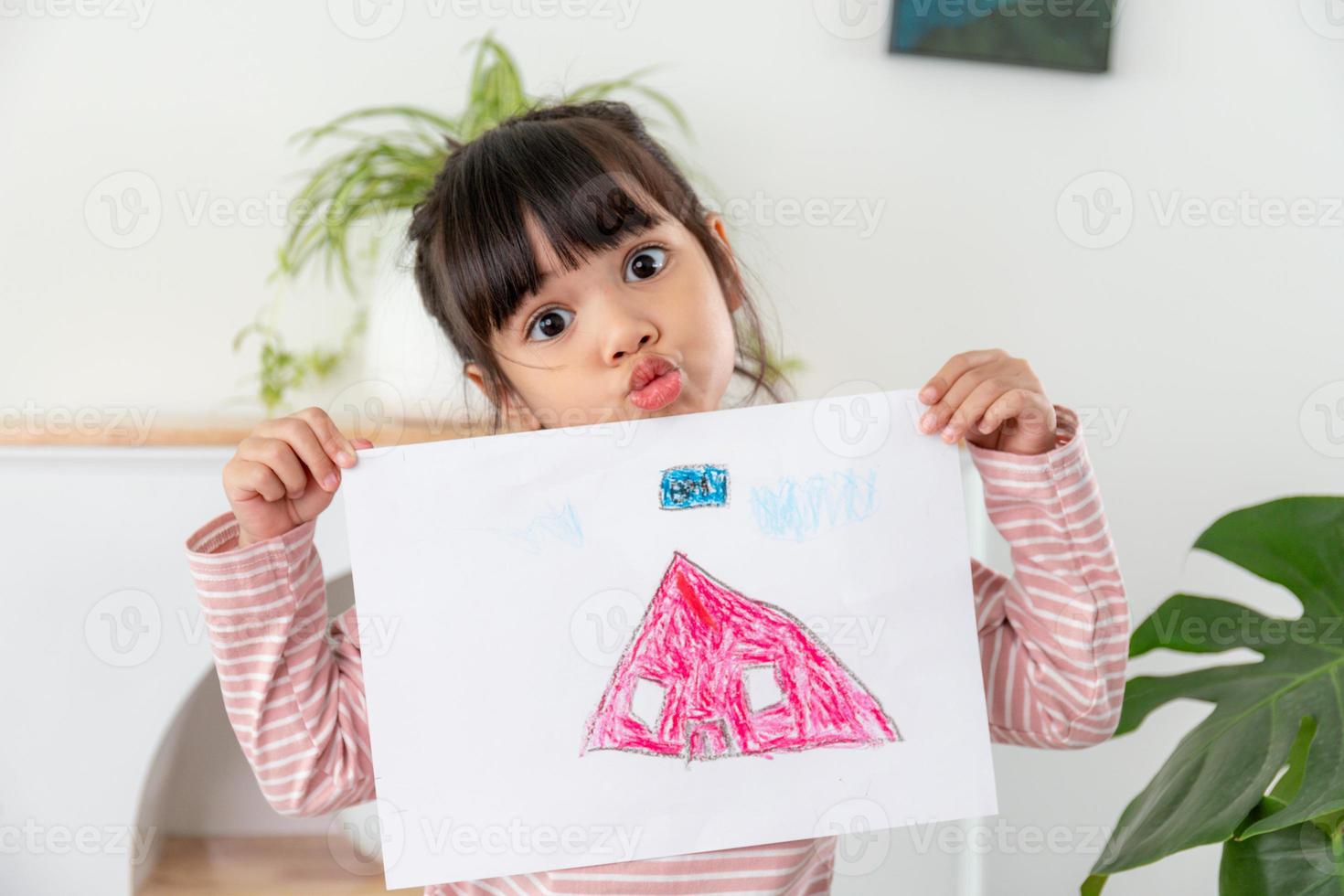 menina pré-escolar exibindo sua foto com orgulho