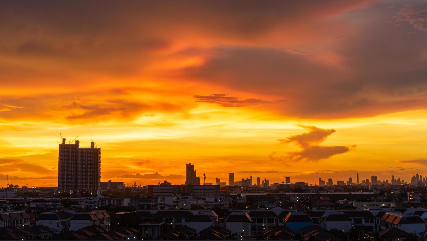 silhueta da cidade e um pôr do sol laranja na Tailândia foto