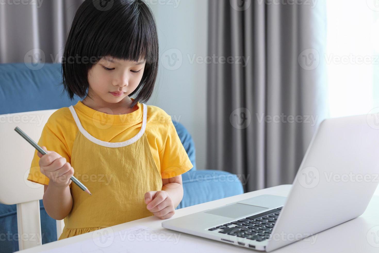 aluna asiática estuda on-line usando o computador portátil em casa foto