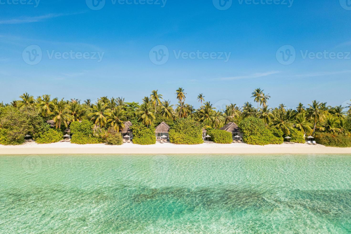 paisagem aérea perfeita, villas privadas de resort tropical de luxo. bela praia da ilha, palmeiras, céu ensolarado. incrível vista de olhos de pássaro nas maldivas, costa paradisíaca. turismo exótico, relaxar natureza mar foto