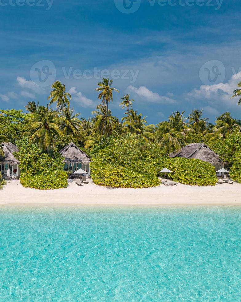 paisagem aérea perfeita, villas privadas de resort tropical de luxo. bela praia da ilha, palmeiras, céu ensolarado. incrível vista de olhos de pássaro nas maldivas, costa paradisíaca. turismo exótico, relaxar natureza mar foto