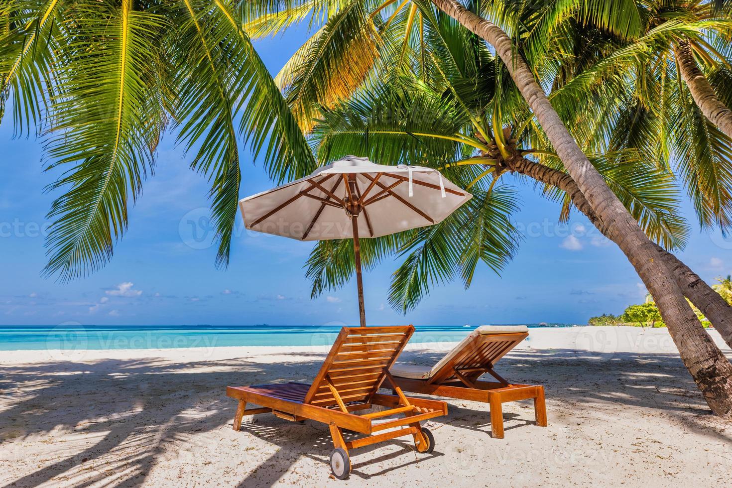 bela ilha tropical, guarda-chuva de cadeiras de casal sob folhas de palmeira, céu de areia do mar paraíso. paisagem de viagens de verão incrível praia de férias. closeup de natureza exótica idílica de relaxamento de recreação. foto