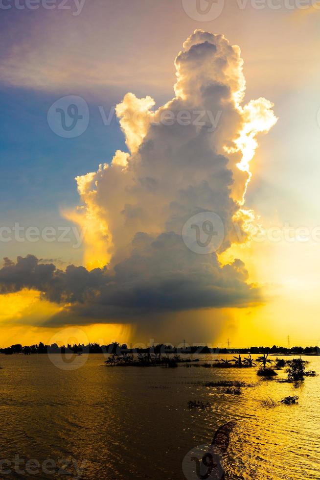 as enormes nuvens estavam se transformando em chuva, escondendo o sol atrás delas. foto