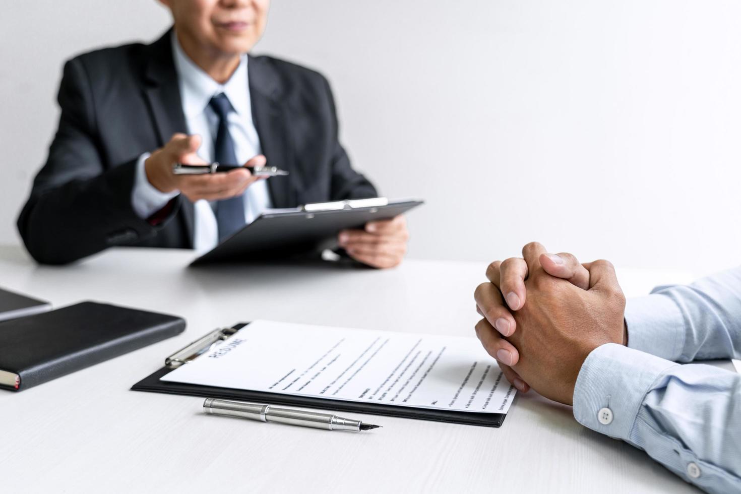 gerente sênior do comitê lendo um currículo durante uma entrevista de emprego foto