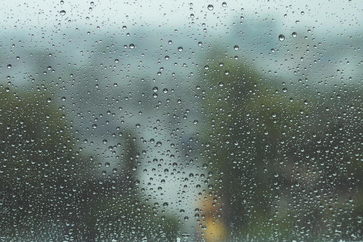 gotas de chuva na janela com fundo desfocado, dia chuvoso, gota de água no vidro, sentindo-se solitário conceito. foto