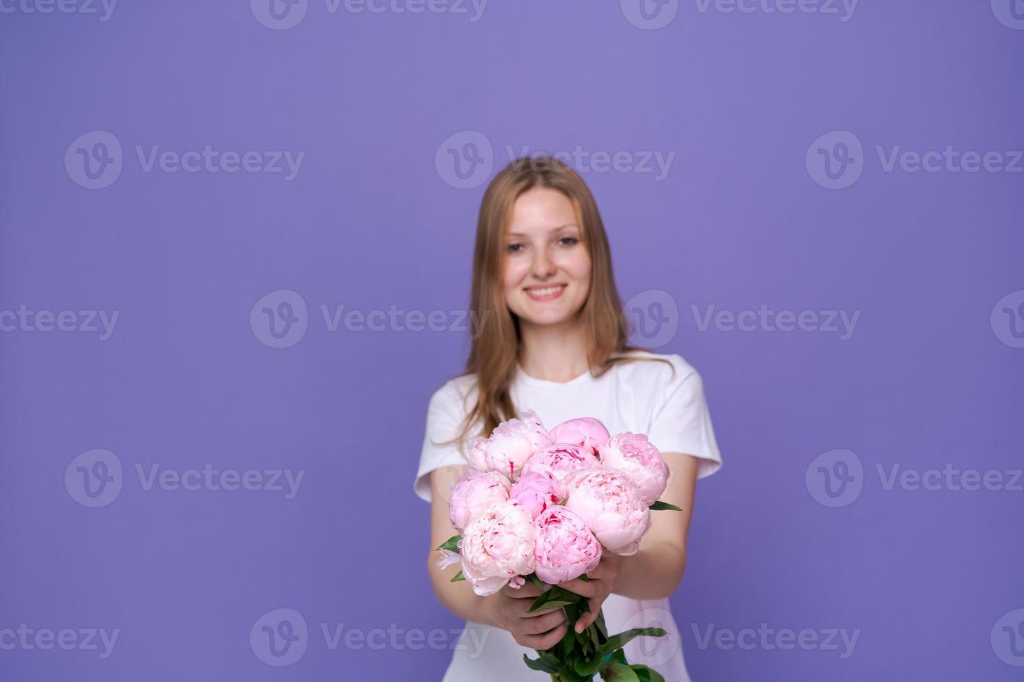 flores para ocasiões especiais. jovem feliz segurando o buquê de peônias rosa foto