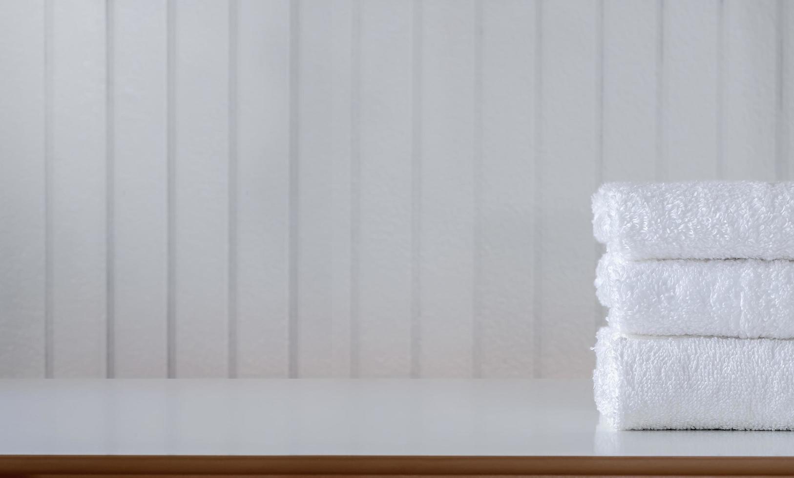 pilha de toalhas brancas dobradas sobre uma mesa foto