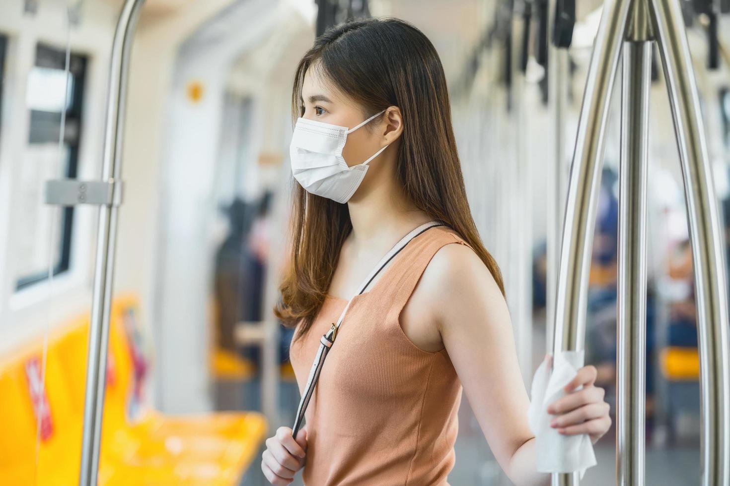 mulher andando de trem com uma máscara foto