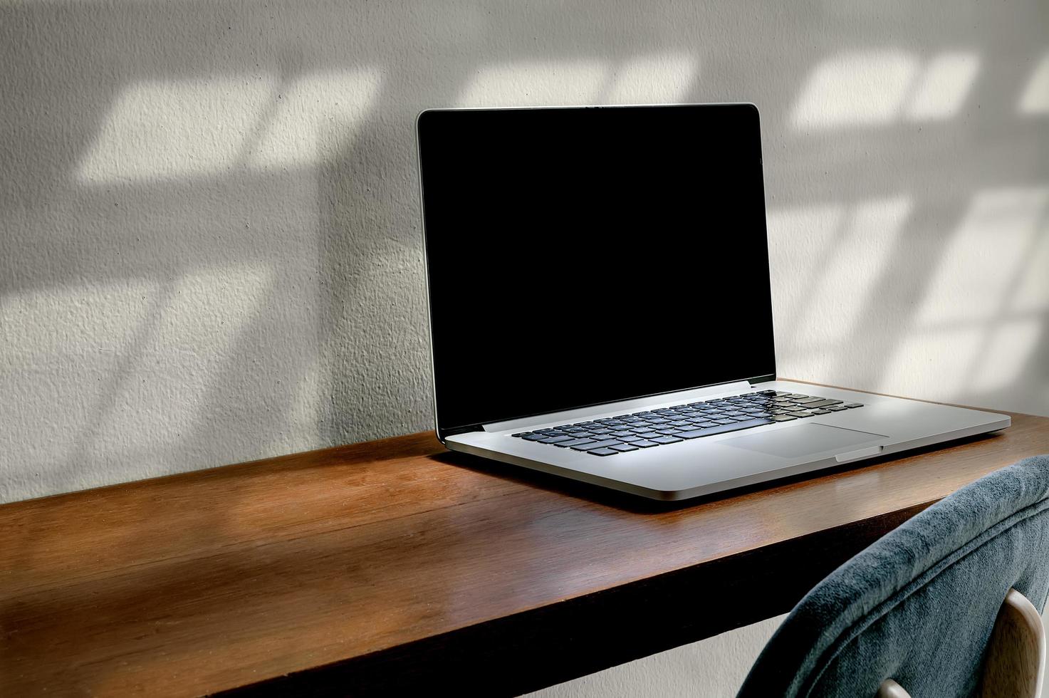 maquete de laptop em uma mesa de madeira foto
