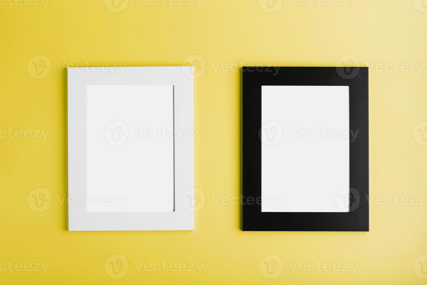 dois quadros moldura branca e preta sobre fundo amarelo com espaço livre. foto