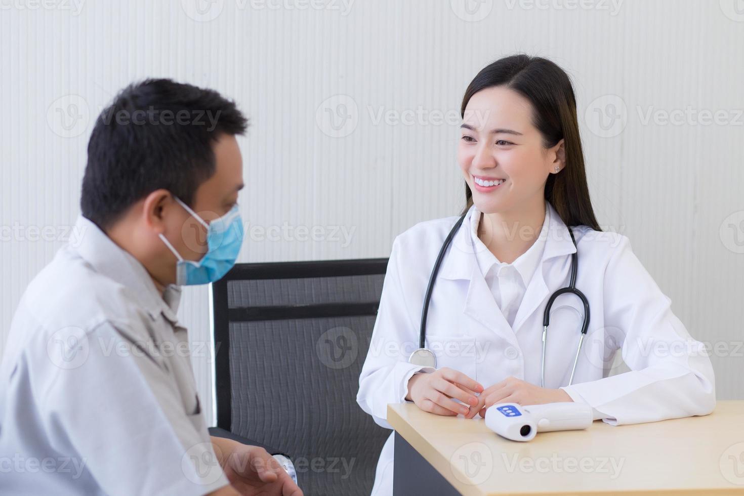 médica asiática fala e encoraja com um paciente homem foto