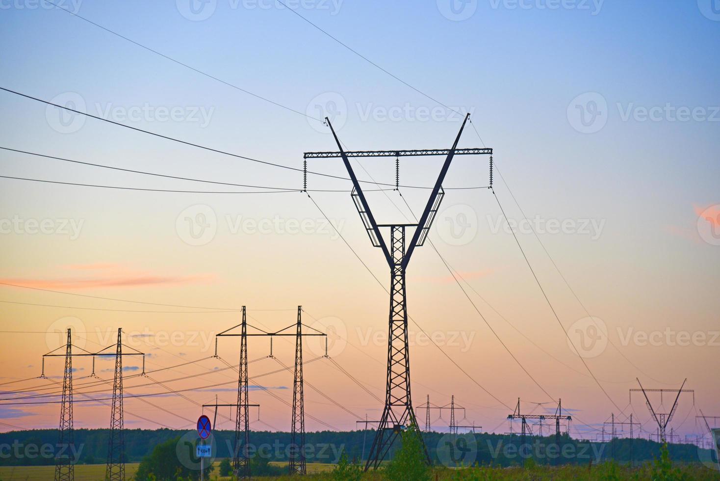 bela linha de transmissão de ferro de alta tensão à noite no céu pôr do sol. noite de paisagem e fios e linhas de energia. foto