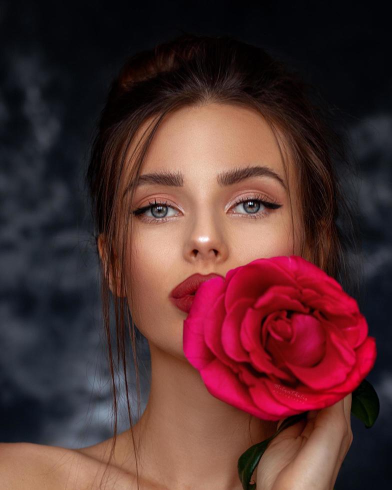 mulher autoconfiante com uma rosa vermelha foto