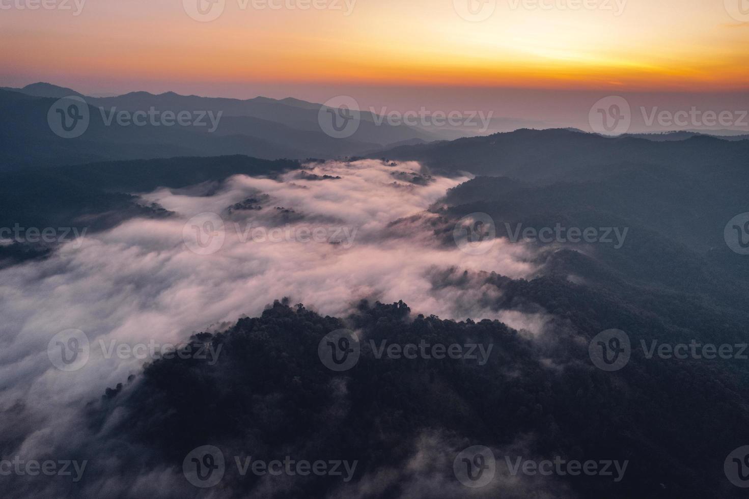 névoa da manhã e nuvens na floresta de colina foto