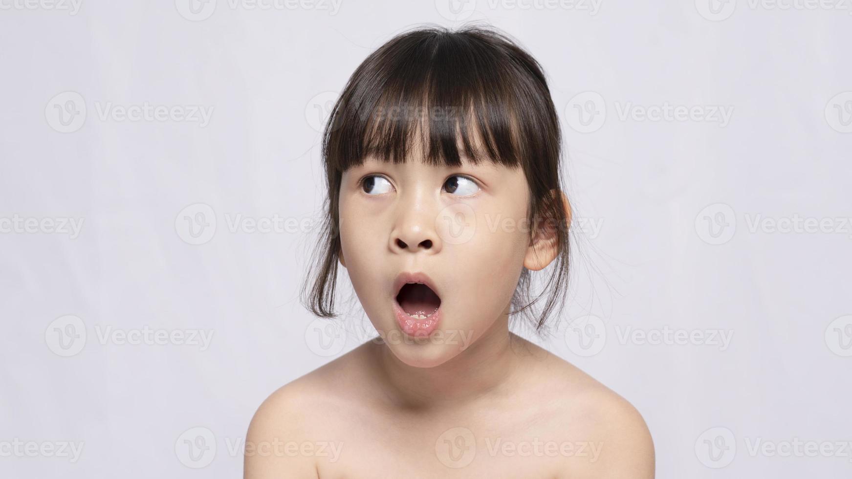 linda jovem asiática parece chocada com as coisas. a garota deu uma expressão de surpresa e olhou para o lado. emoções faciais expressivas foto