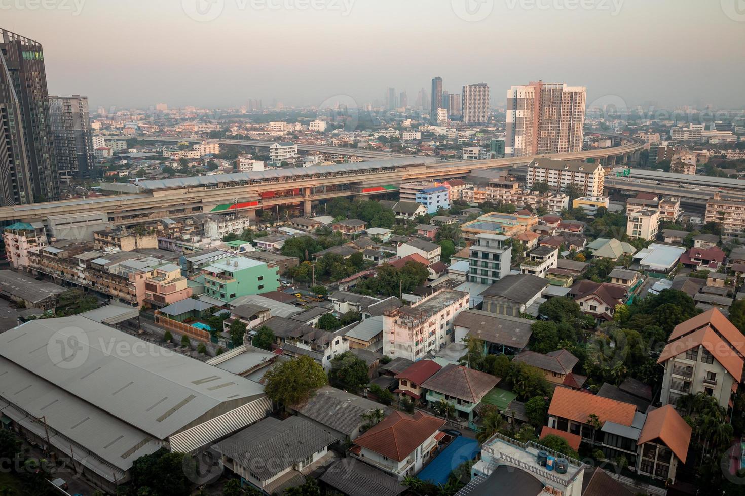 vista aérea da metrópole no céu pôr do sol, edifícios, estradas e rotas de trem elétrico. foto