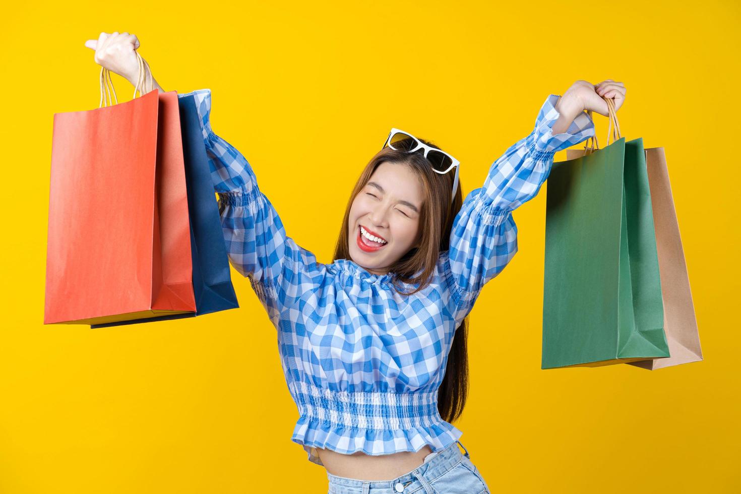 jovem atraente carregando sacolas coloridas foto