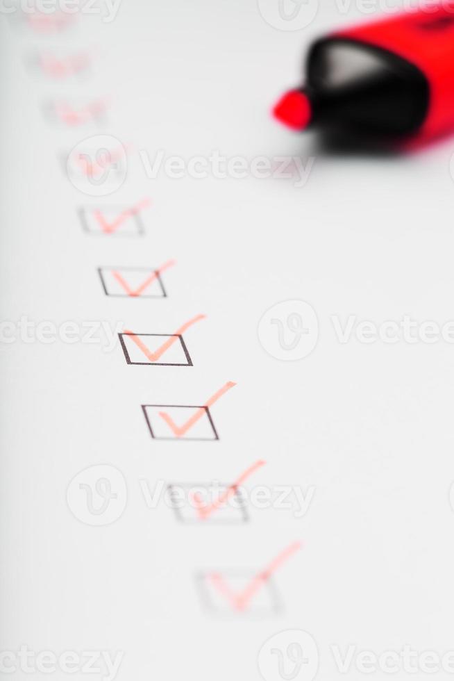 marcador laranja com marcadores na folha da lista de verificação. foto