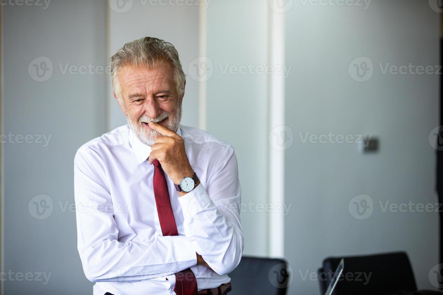 homem de negócios idoso em pé com confiança sorrindo e rindo feliz na sala de reuniões foto