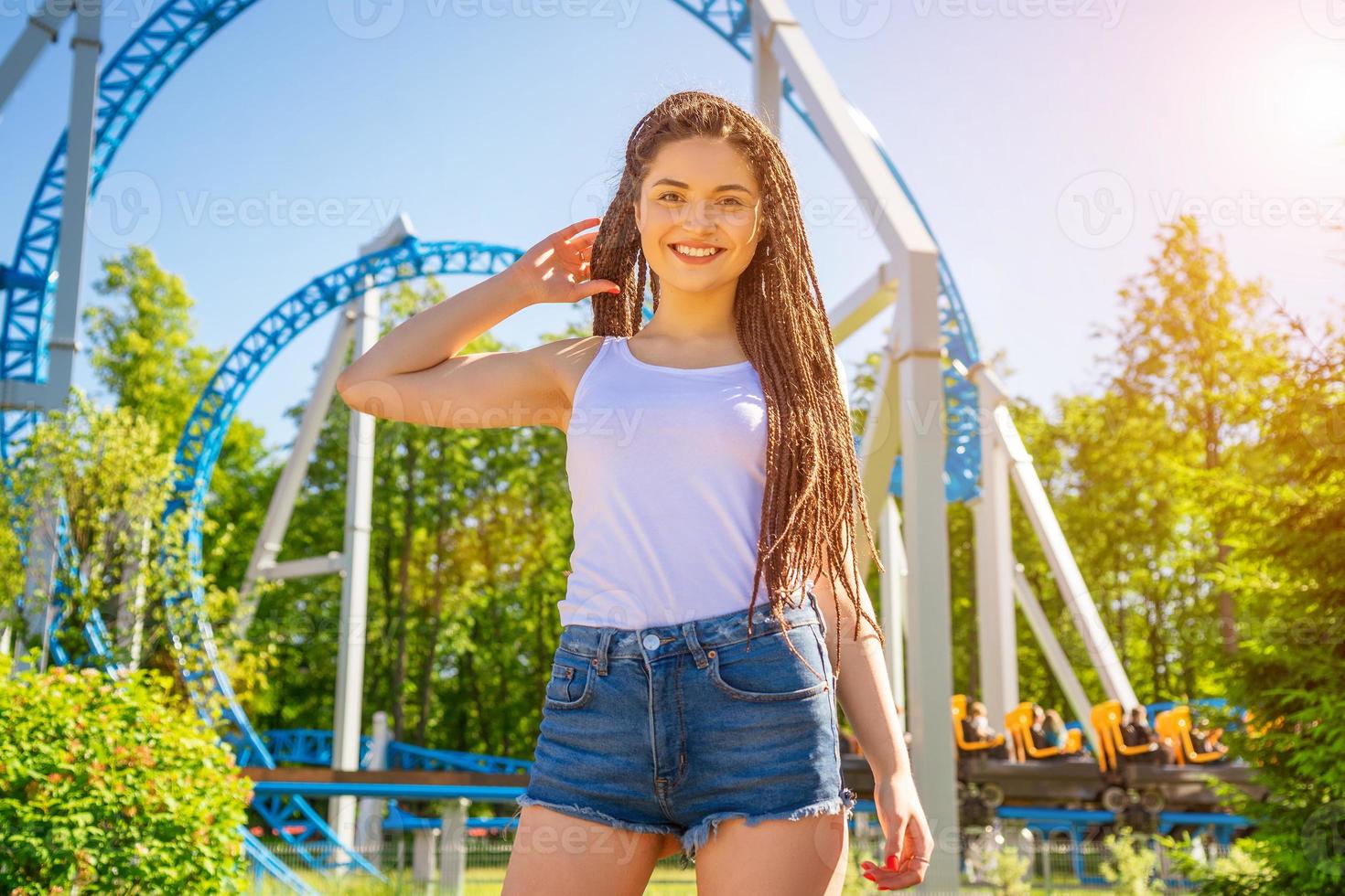 garota engraçada com dreadlocks no fundo de um parque de diversões foto