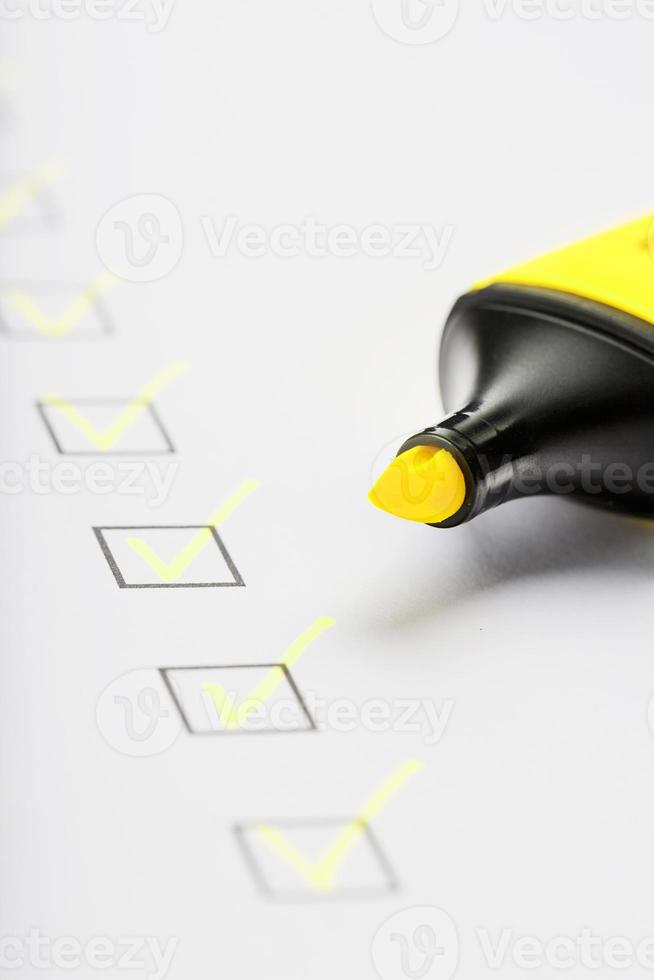 marcador amarelo com marcadores na folha da lista de verificação. foto