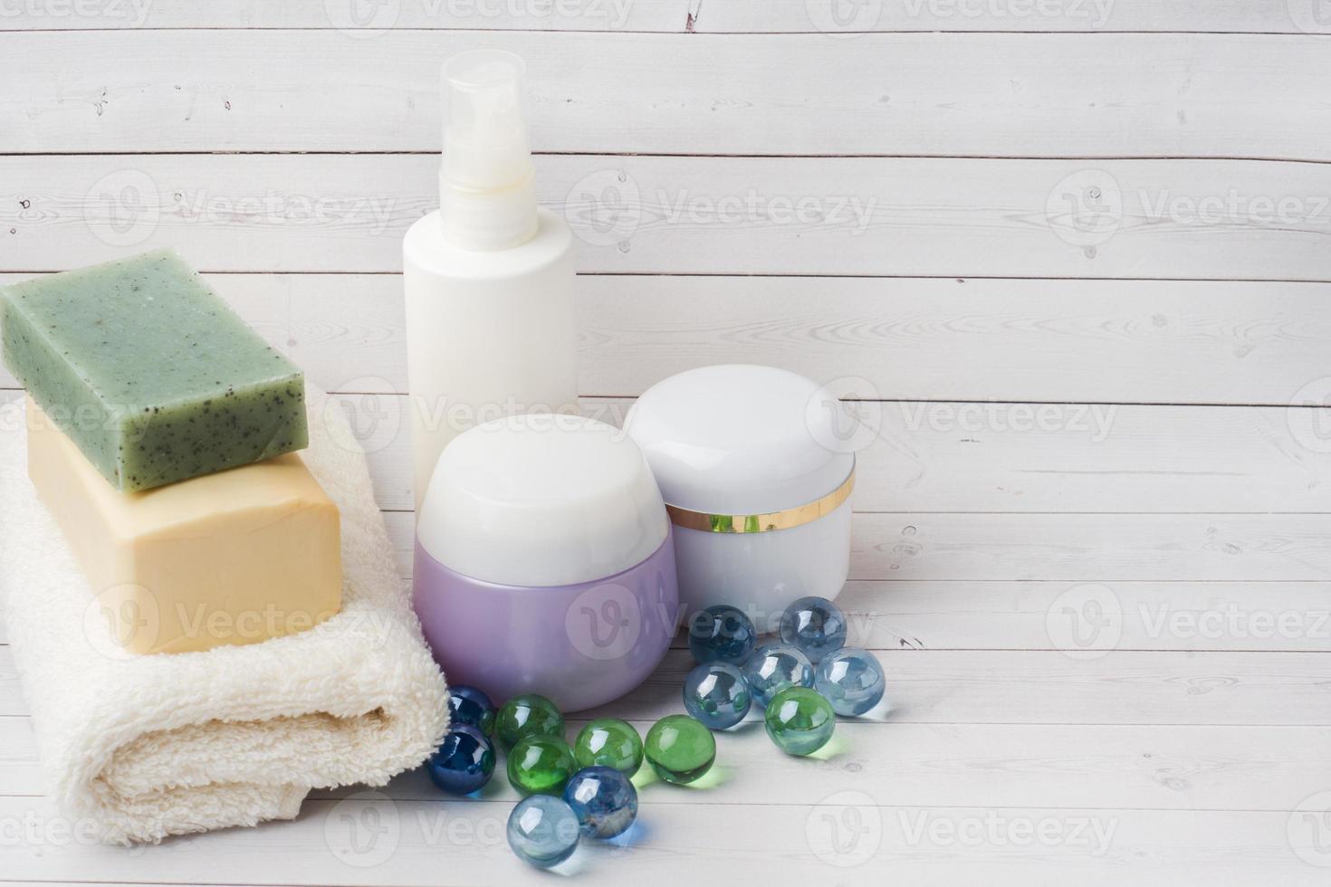 conceito de spa e bem-estar em fundo branco. toalhas sabonete creme e acessórios de banho. espaço de cópia foto