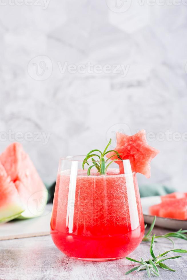 suco de melancia fresco em um copo em cima da mesa. bebidas refrescantes de verão. visão vertical foto