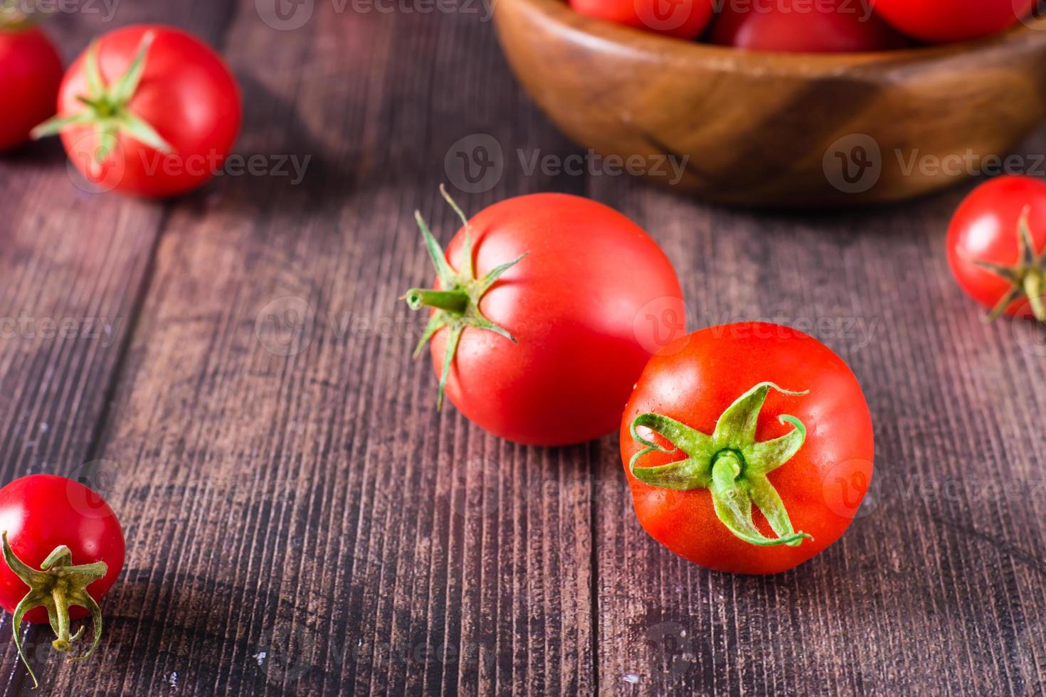 tomates orgânicos maduros em uma mesa de madeira. colheita e produtos locais. foto