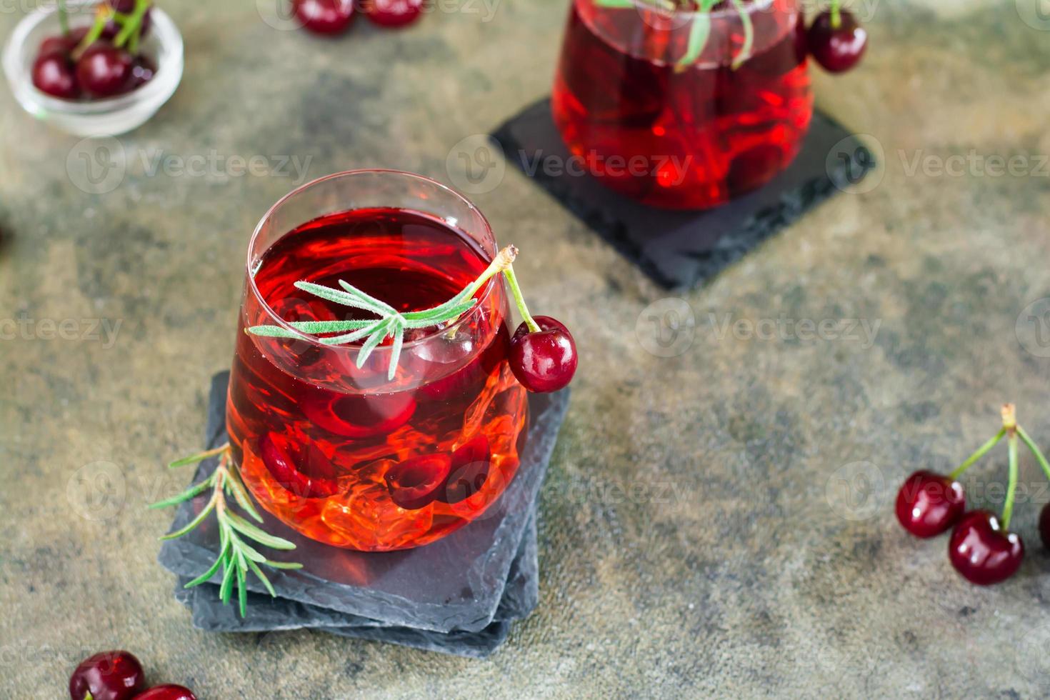 coquetel com cereja, alecrim e gelo em copos na mesa. mocktails caseiros foto