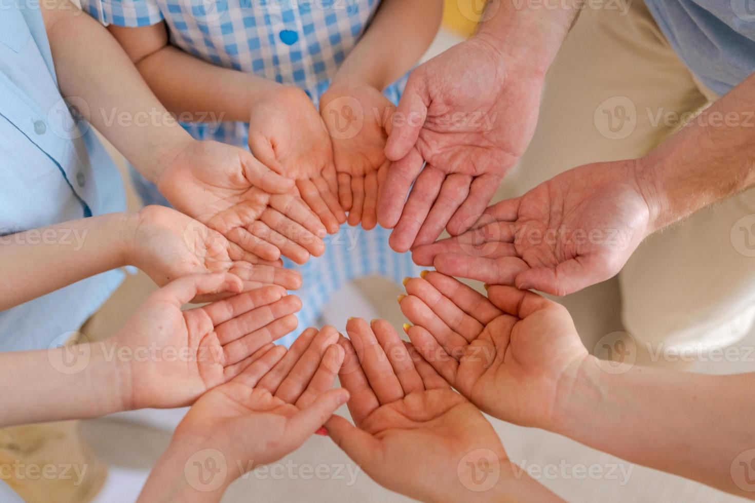 grande família mantém as palmas das mãos juntas, conceito de felicidade na família foto