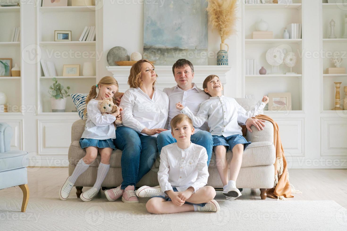 retrato grande família passar tempo juntos em casa. eles estão sentados felizes foto