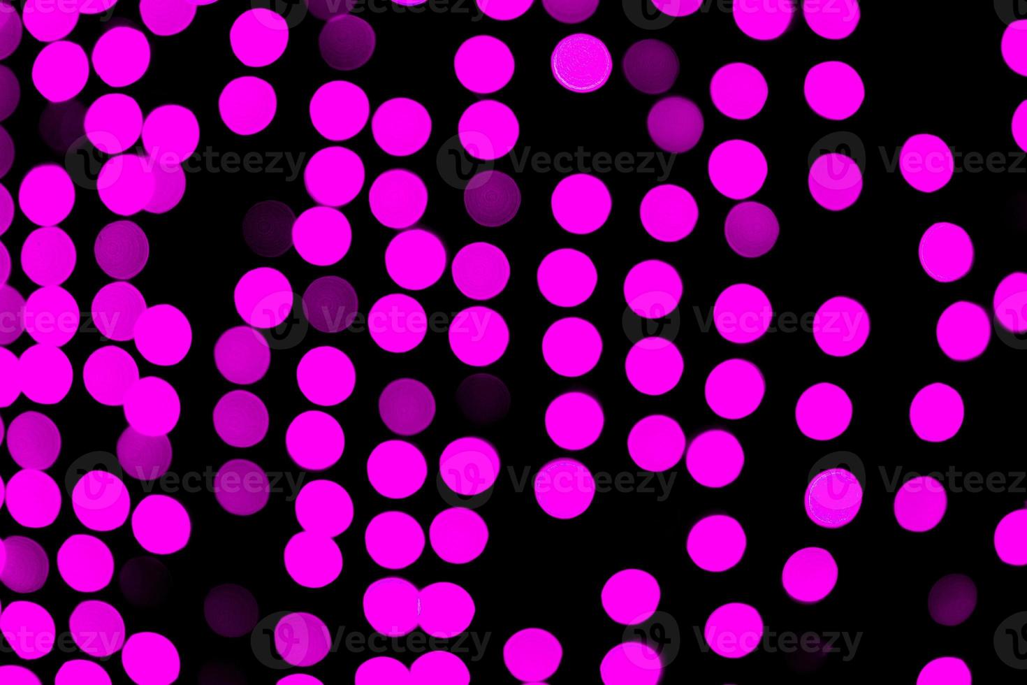 bokeh rosa abstrato sem foco em fundo preto. desfocado e desfocado muitas luzes redondas foto