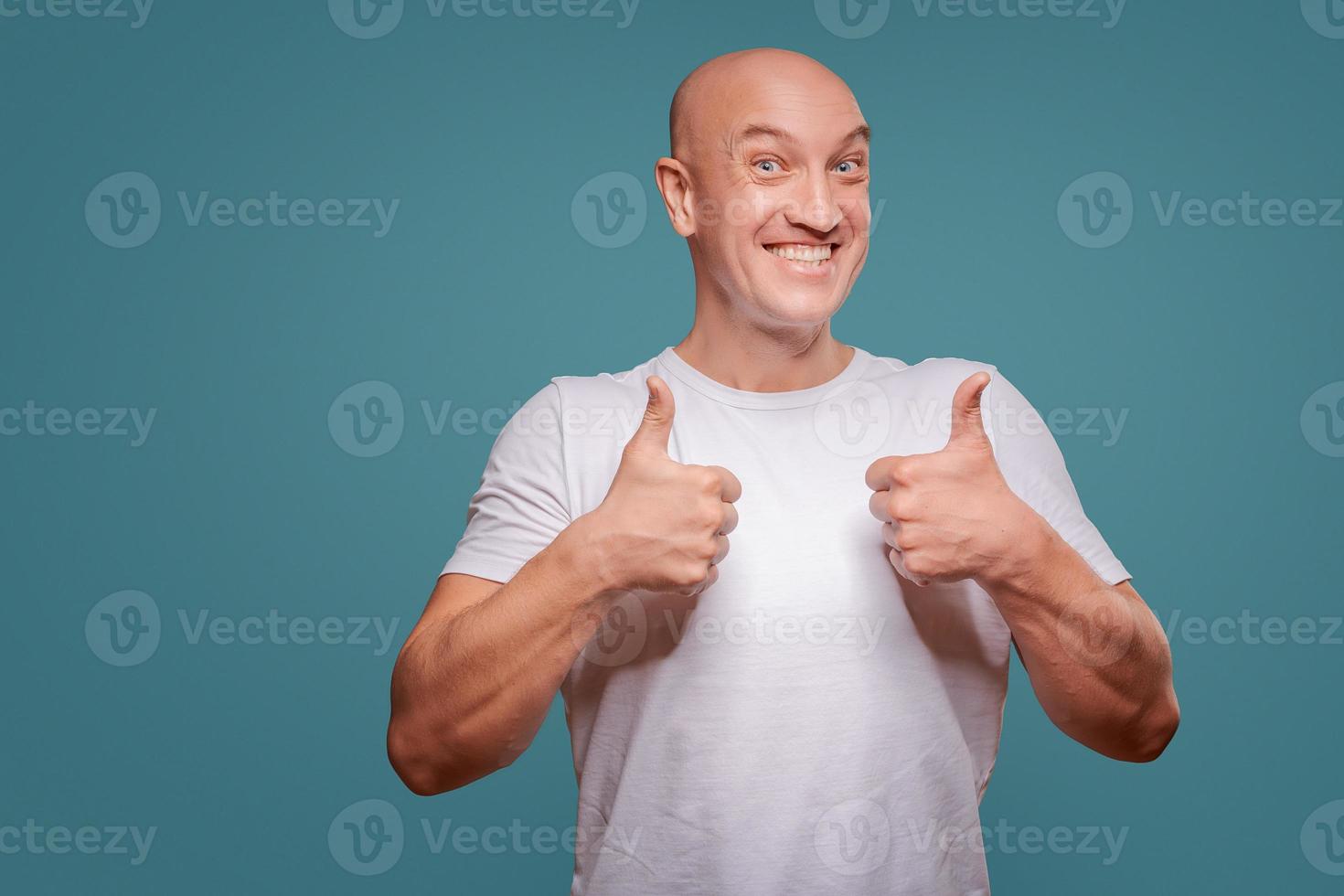 retrato de um homem alegre mostrando gesto bem isolado no fundo azul foto