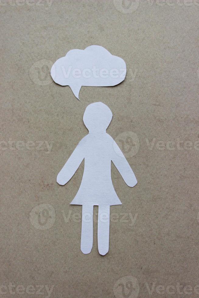 a silhueta de uma mulher em um vestido feito de papel branco, cortado à mão. com balão de fala no centro da foto vertical