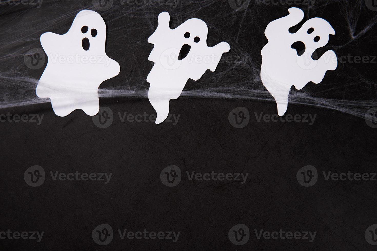 decoração de halloween e conceito de horror - teia de aranha com fantasmas sobre fundo preto foto