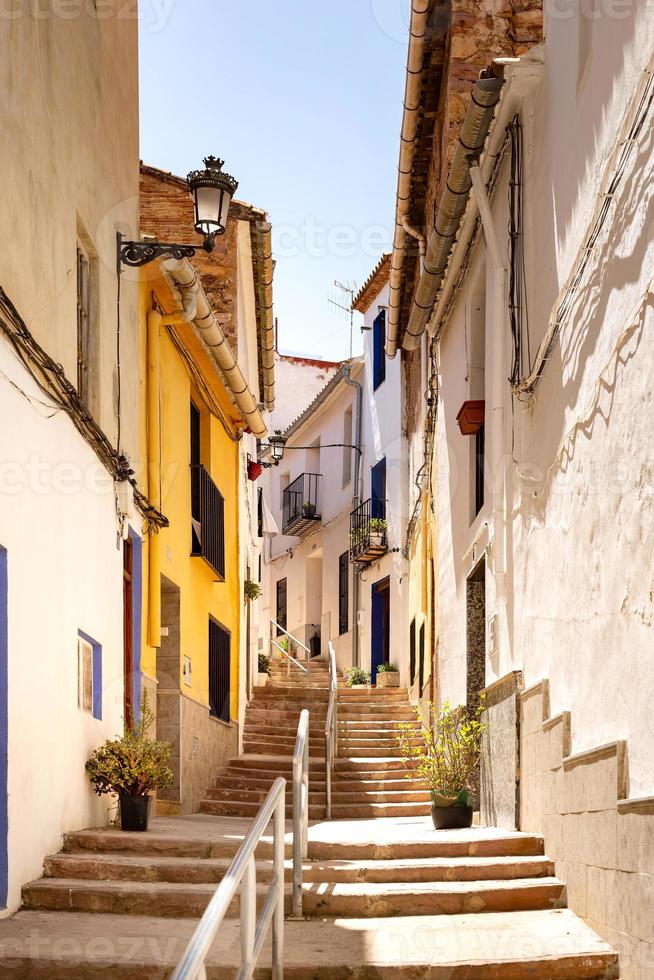 foto vertical de uma vista em uma pequena rua curva com uma escada subindo