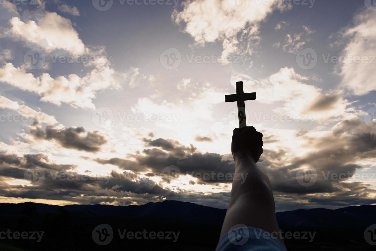 silhueta de mãos de mulher rezando com cruz no fundo do nascer do sol da natureza, crucifixo, símbolo de fé. oração de crise da vida cristã a deus. foto